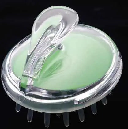 Masajeador de cuero cabelludo de silicona verde con mango ergonómico para limpieza capilar.